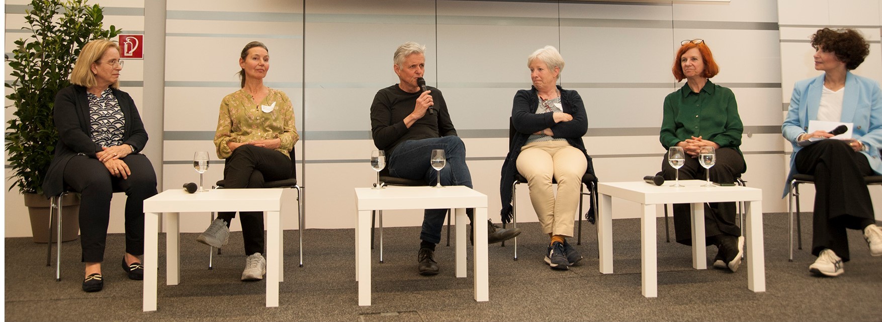 Podiumsdiskussion bei der österreichweiten Fachtagung Frühe Hilfen 2023 am FH Campus Wien. Sechs Fachpersonen aus dem deutschsprachigen Raum sitzen auf einer Bühne und diskutieren Erfahrungen und Perspektiven der Frühen Hilfen in ihren Ländern.